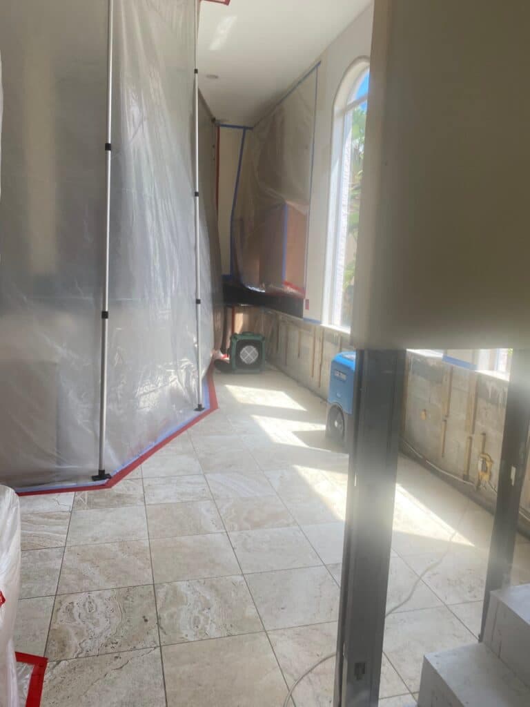 Containment sheeting protecting a tiled hallway during remediation