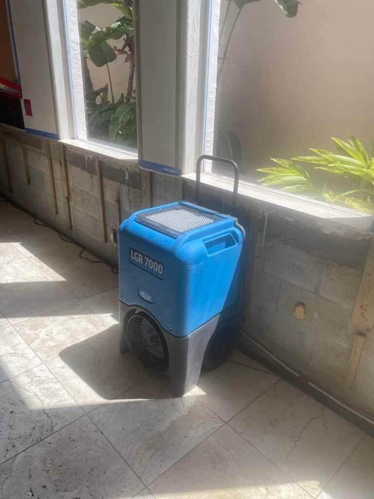 Commercial LGR dehumidifier drying a flood-cut wall during TLG Restoration water damage work in Palm Beach County