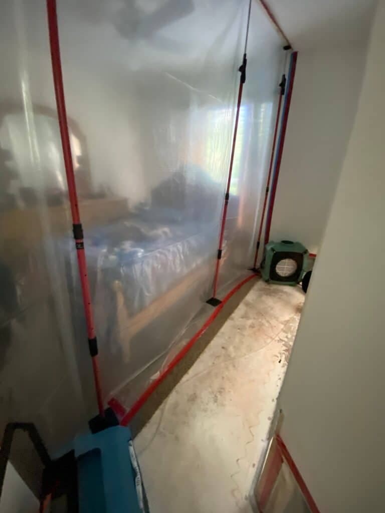 TLG Restoration containment barrier and HEPA air scrubber protecting a West Palm Beach bedroom during mold remediation