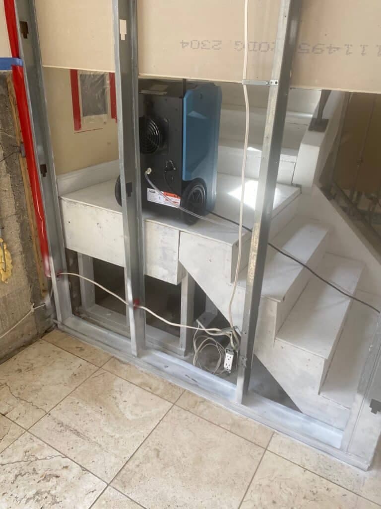 Air movers positioned for structural drying at a staircase